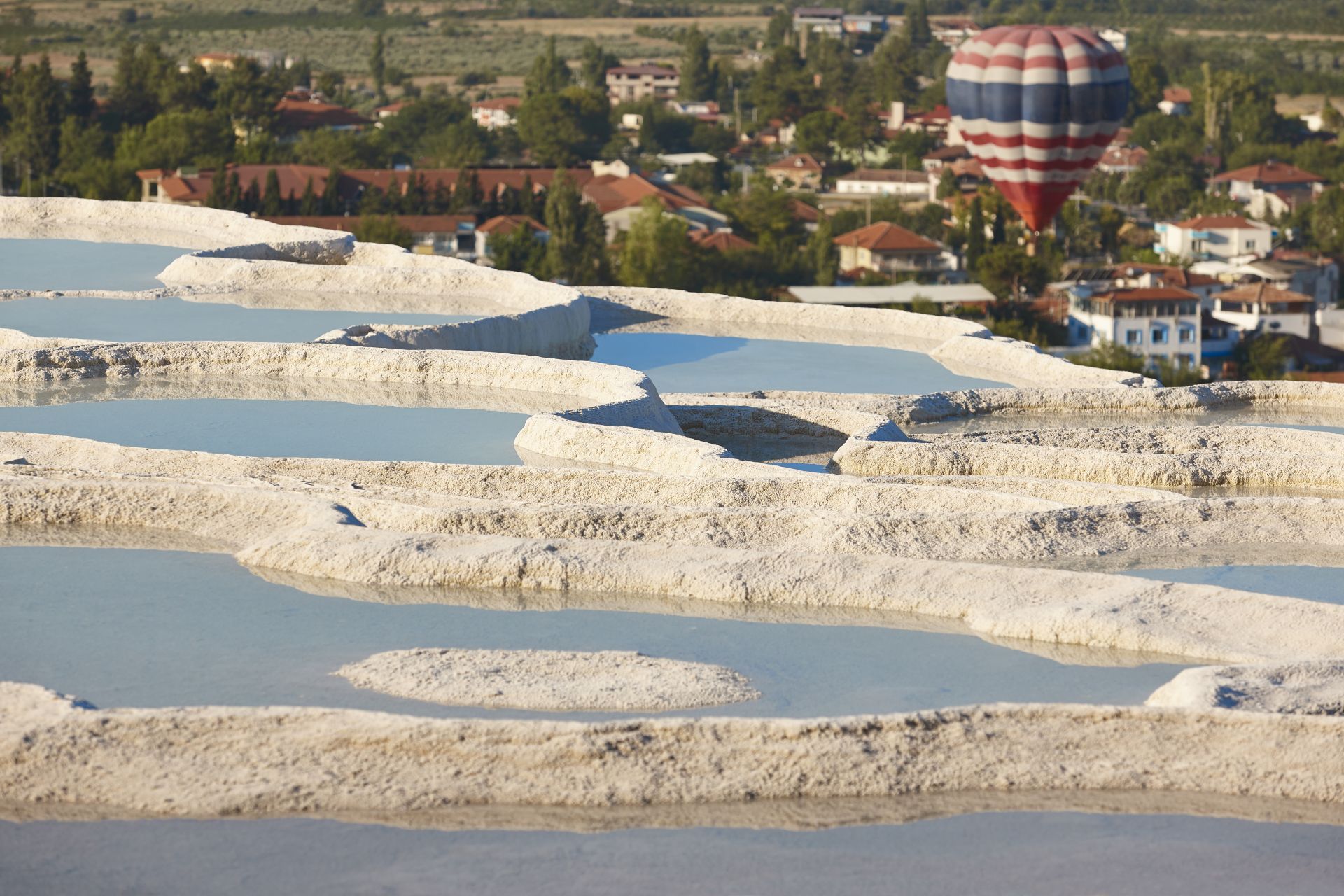 Pamukkale white mineral limestone natural pools and balloon. Tur
