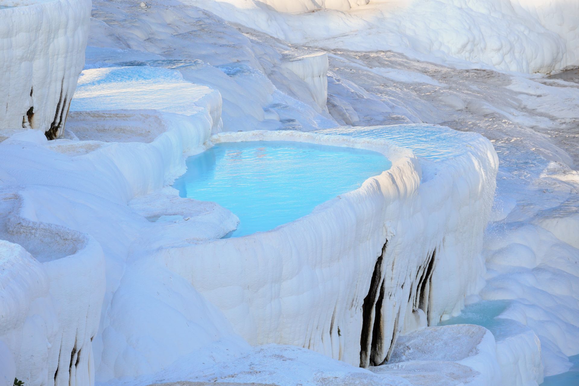 Travertine terraces with clear blue water in Pamukkale
